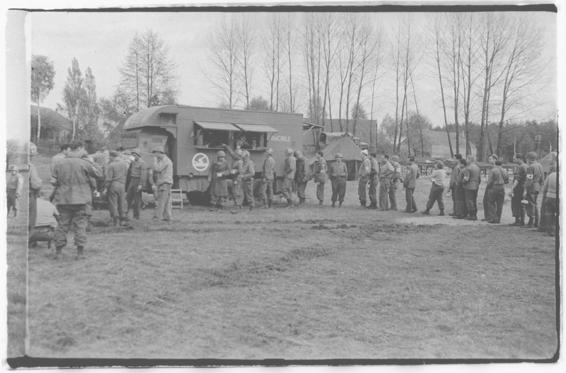 US Army officers from the 91st Evacuation Hospital Unit stand in line for food.