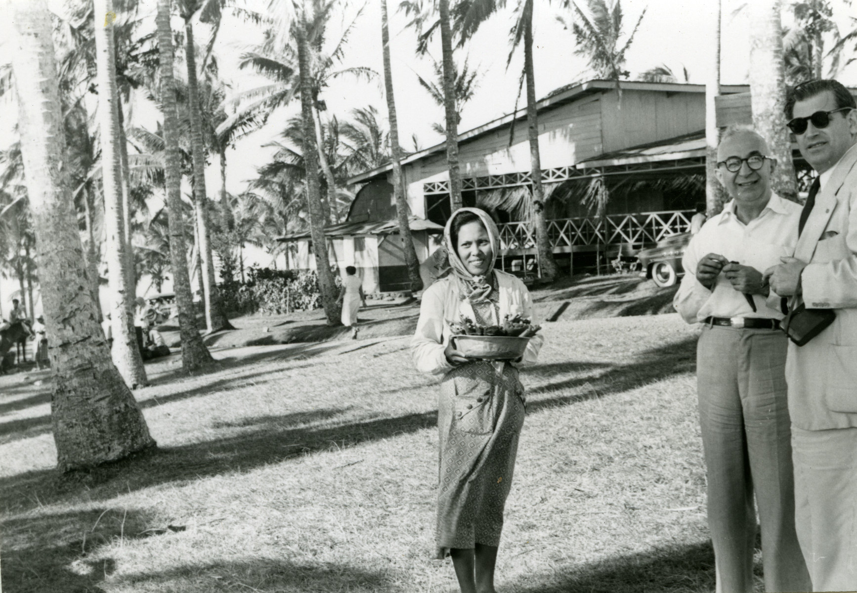 A Filipino woman carries a basket of food.  

Dr. Harry Price is pictured on the right.