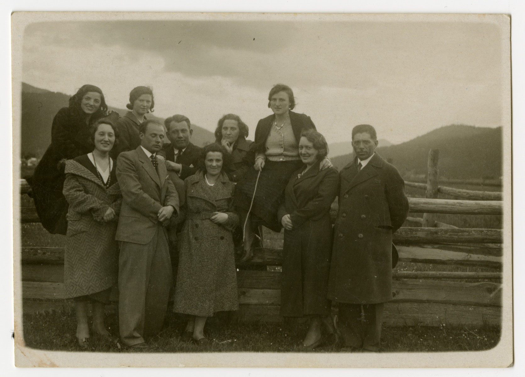 A group of Jewish family and friends stands in the Skole countryside by a fence.

Pictured standing in the first row, from left: Szajna Friedler, Beno Rozenberg, unidentified; Lotka Friedler and unidentified.  In the second row, from left: unidentified; Mania Rozenberg; Moshe Josefsberg; unidentified and Frieda Rozenberg Josefsberg.