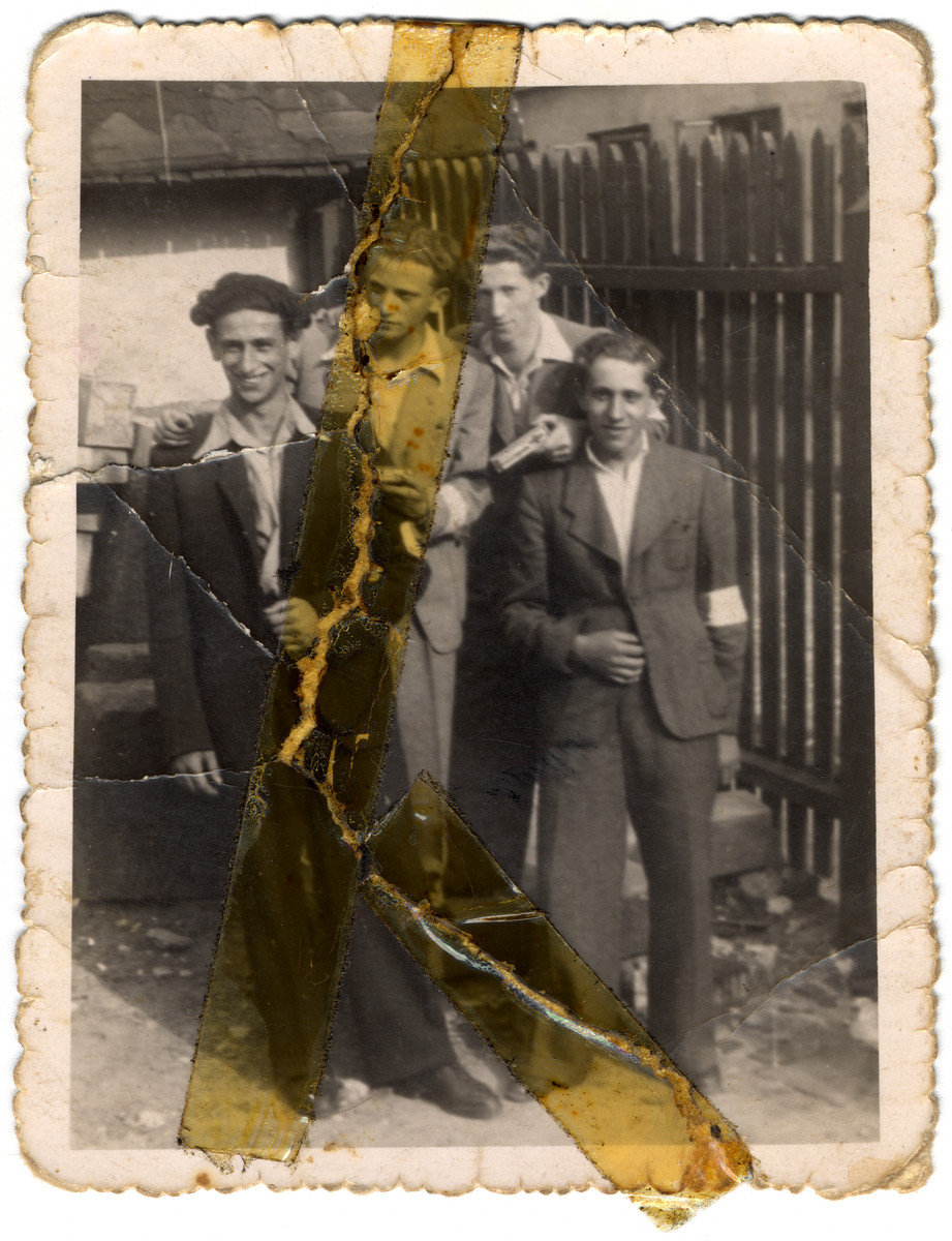 A group of Jewish youths pose next to a fence.

Among those pictured are Sruleck Slomnicki (far left) and Zigmund Weinrib, a photographer (second from the left).

Sala Slomnicki carried this photograph with her in her shoe throughout her time in forced labor camps.