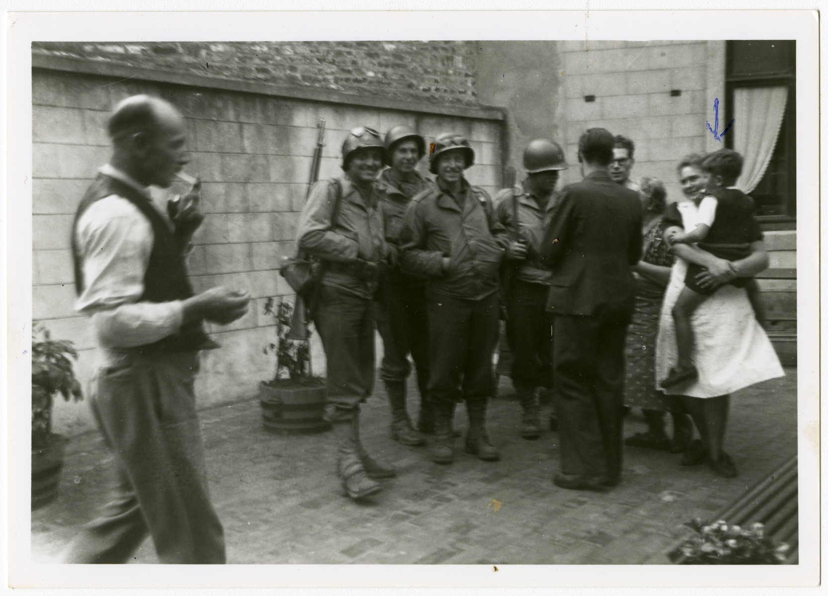 American soldiers liberate the town of Perwez.

Pictured on the right is Mrs. Hemptine Stas, the wife of the butcher, who was hiding the Jewish child Albert Szabo who she is holding.  She lived next door to the Henrards, the rescuers of Simon Steil.