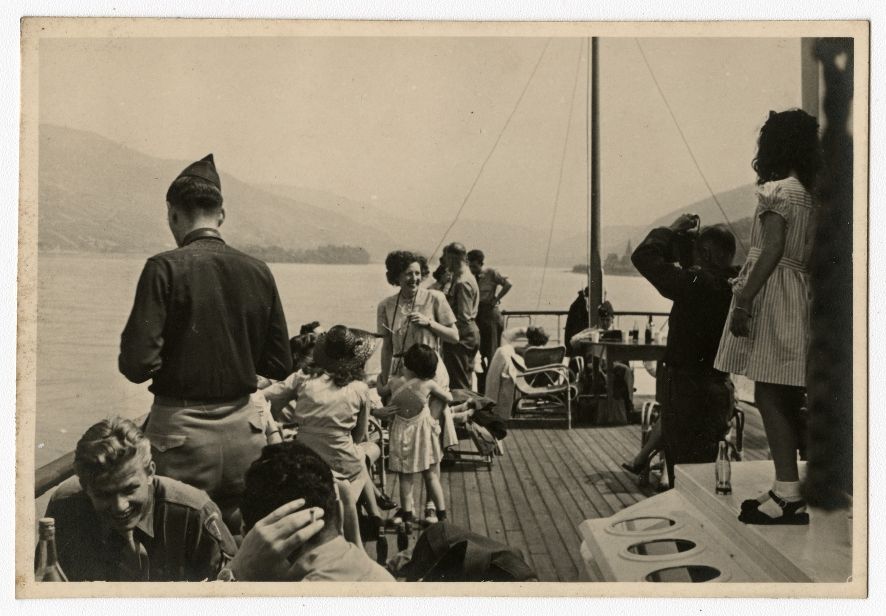 American soldiers and civilians enjoy an excursion on Hitler's yacht.

Original caption reads, "Deck of Hitler's yacht."