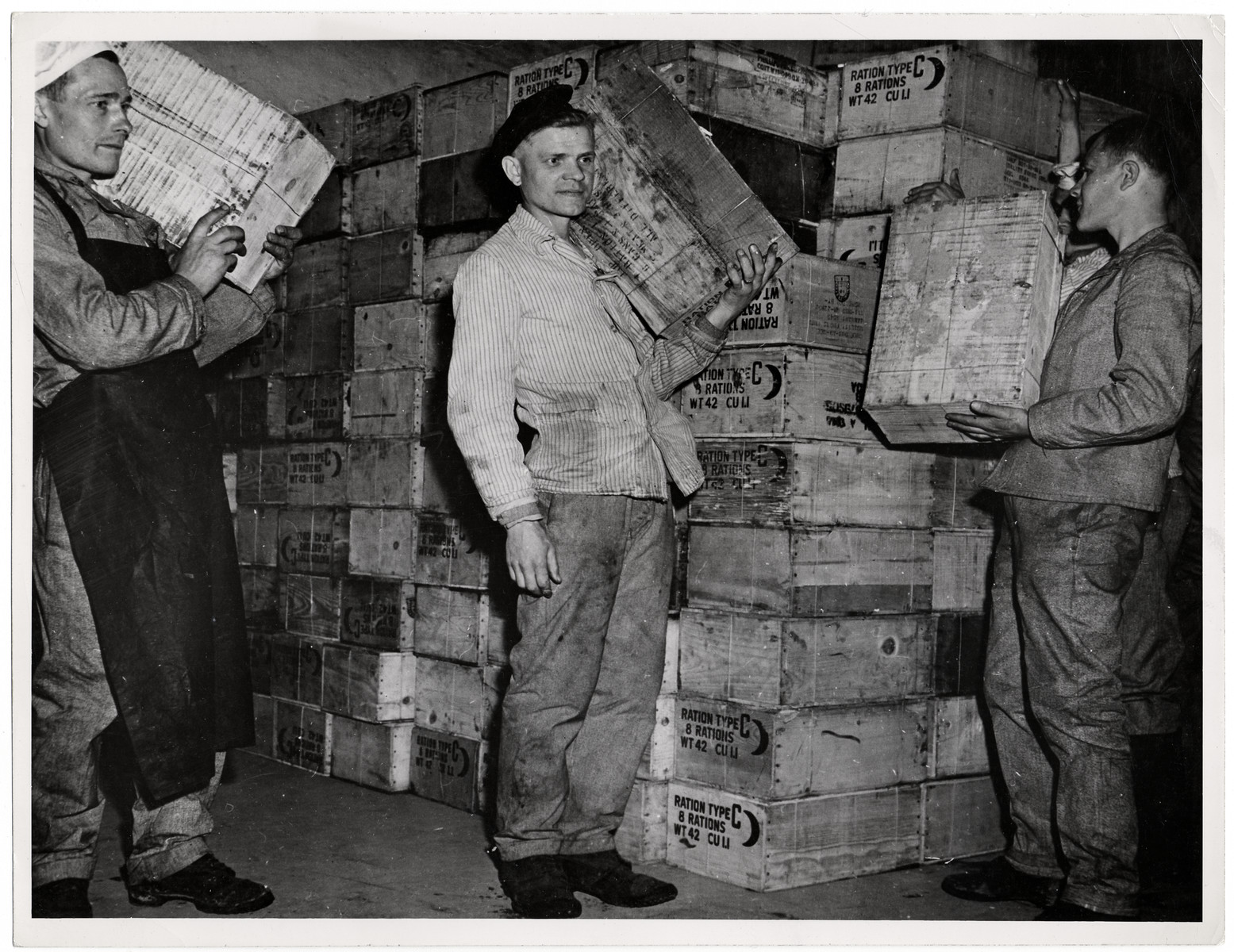 Recently liberated Soviet POWs enjoy American food rations.

Original Caption: "Russian prisoners of war liberated in Hemer, Germany, by the Ninth US Army celebrated May Day, 1945 by holding a banquet of 'C' rations. Infantrymen of the 75th Infantry Division are shown handing out boxes of the rations for the banquet. There were 22,000 Russians in the Hemer camp, 9,000 of them hosptial cases suffering from tuberculosis, dysentery, typhus and malnutrition."