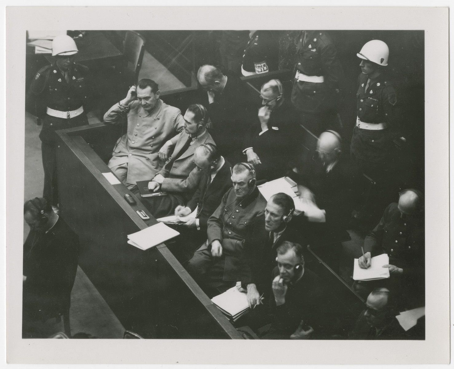 Photograph of the defendant's dock at the International Military Tribune in Nuremberg. 

Seated in front row from left to right: Goering, Hess, von Ribbentrop, Keitel, Kaltenbrunner and Rosenberg.