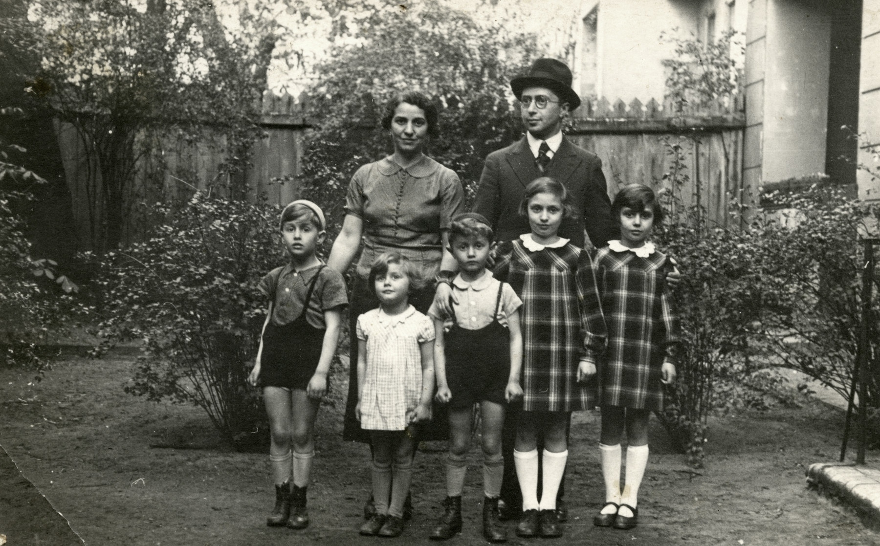 The Birnbaum family poses in a garden while on vacation near Berlin.

From left to right are Yaakov, Susy, Zvi, Sonni and Regina.  Hennie and Yehoshua are standing behind them.