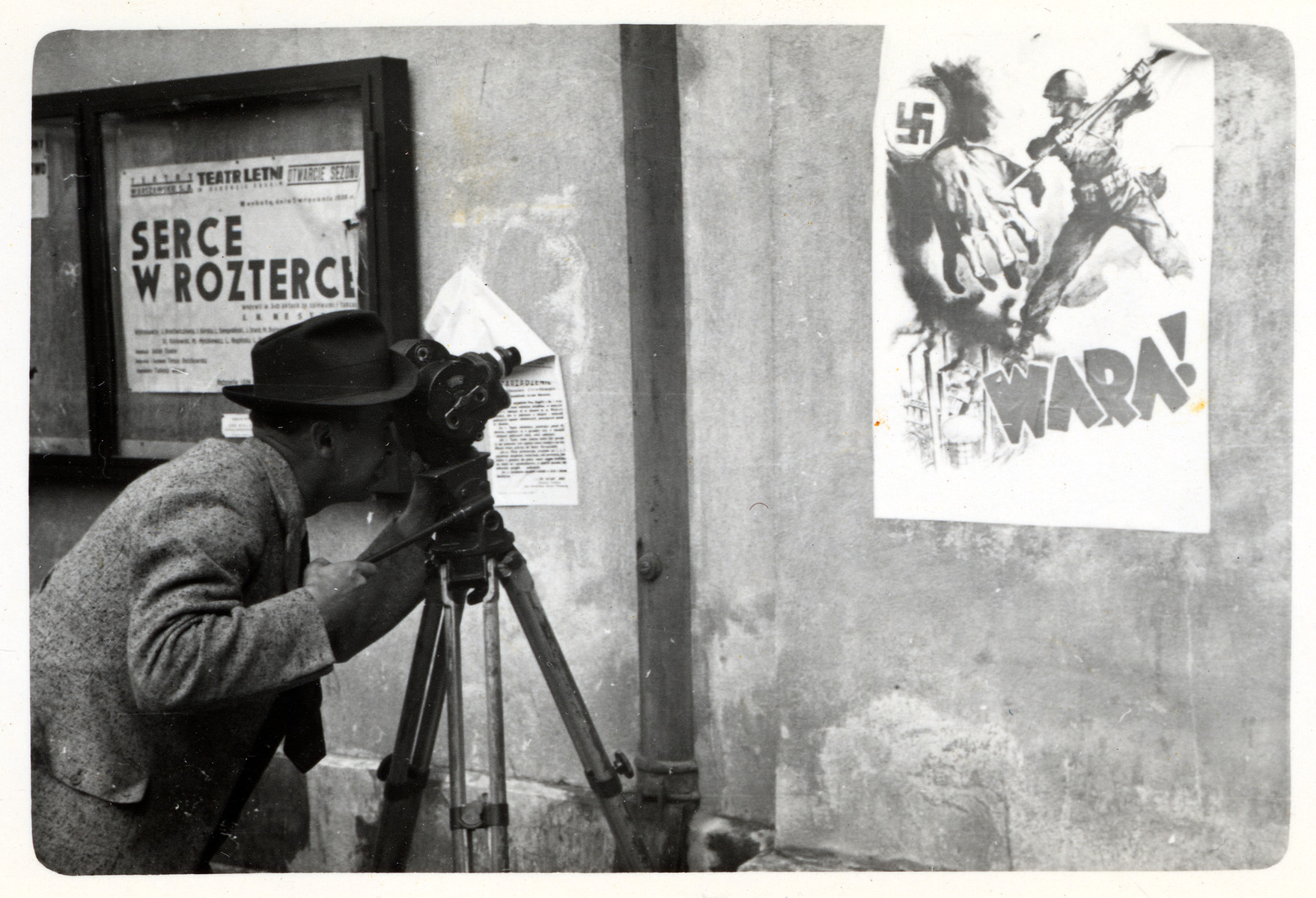 Julien Bryan films an anti-Nazi propaganda poster affixed to a wall in besieged Warsaw.