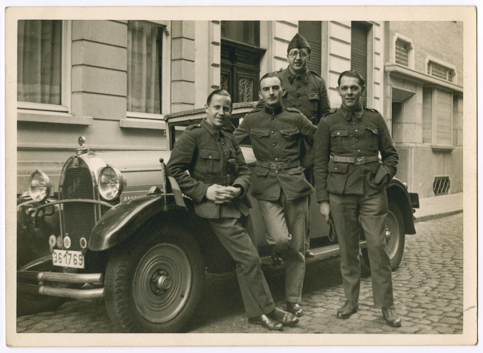Four Belgian soldiers pose by an automobile.

Leopold Guttman is pictured in the top, center.