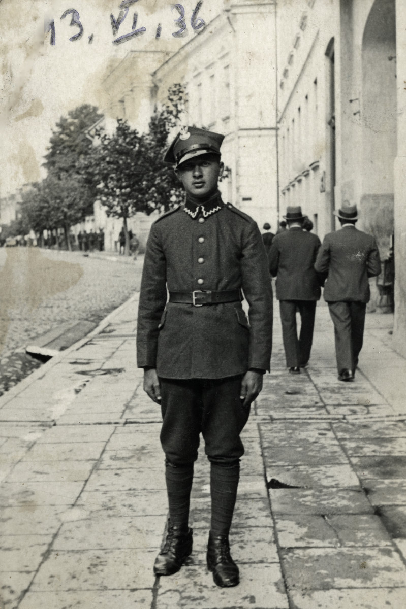 Moshe Volovelski poses on a sidewalk in his Polish army uniform.