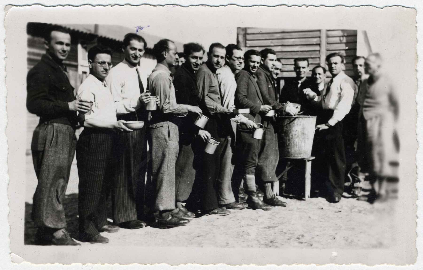 Prisoners wait in line for their rations in the Beaune-la-Rolande transit camp.

The original caption reads "Soup distribution."

Pictured third from left is Chil Jankiel Sztal and fourth from left is Jankiel Michalowicz.