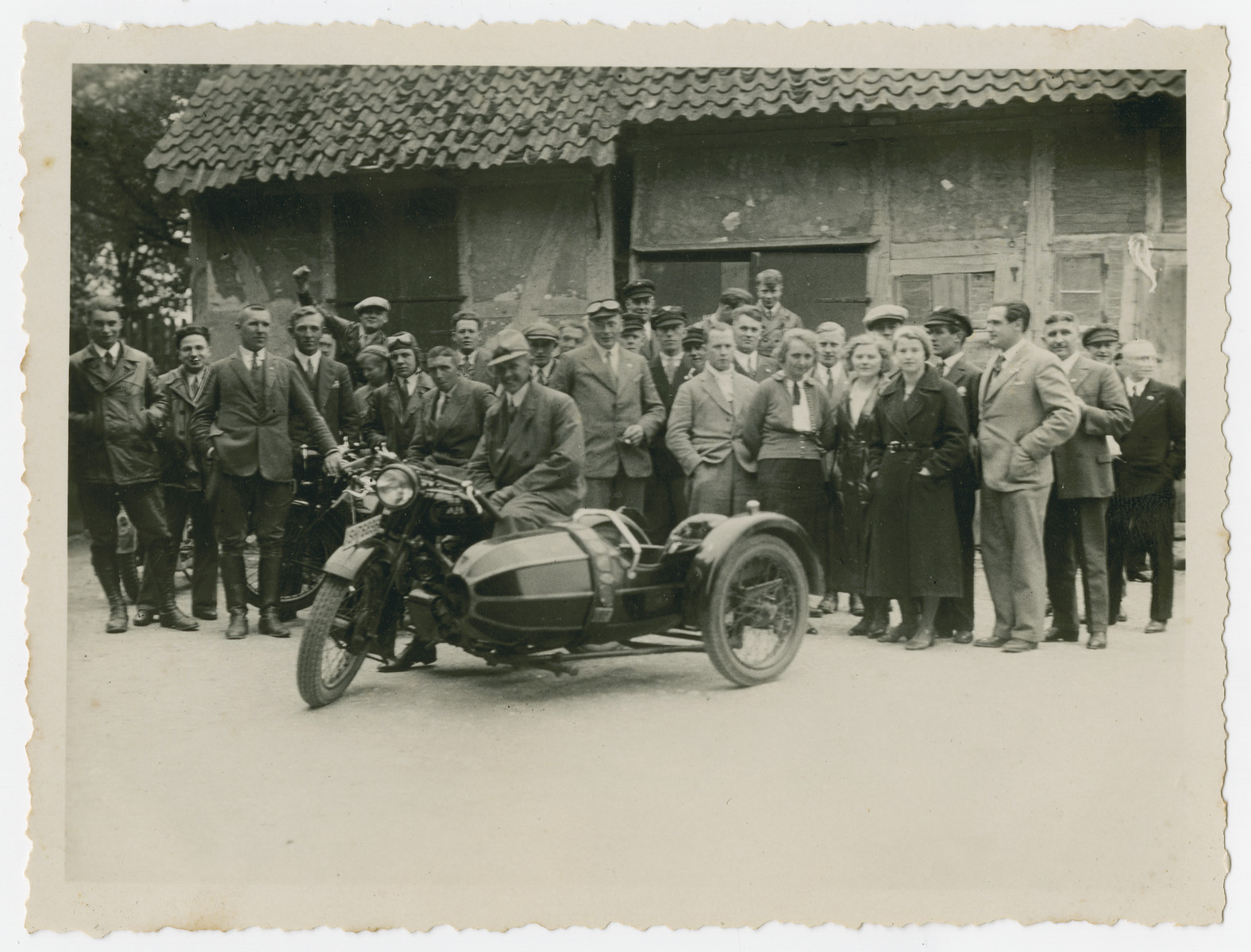 Group portrait of members of a motorcycle club,

The original caption "Fox Hunt" refers to the orienteering game played by members of the club.  Walter Kleeblatt is pictured second from the left.  One of the members (back left) raises a fist in the communist "Red Front" greeting.