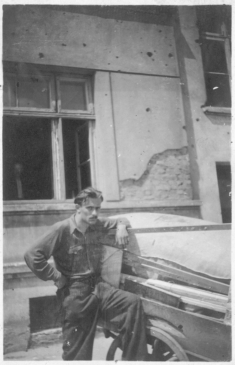 Shmuel Willenberg leans against a cart holding the family's household belongings after receiving an eviction notification.

His father Perec is staring out of a window in the background.  They were living with false papers.