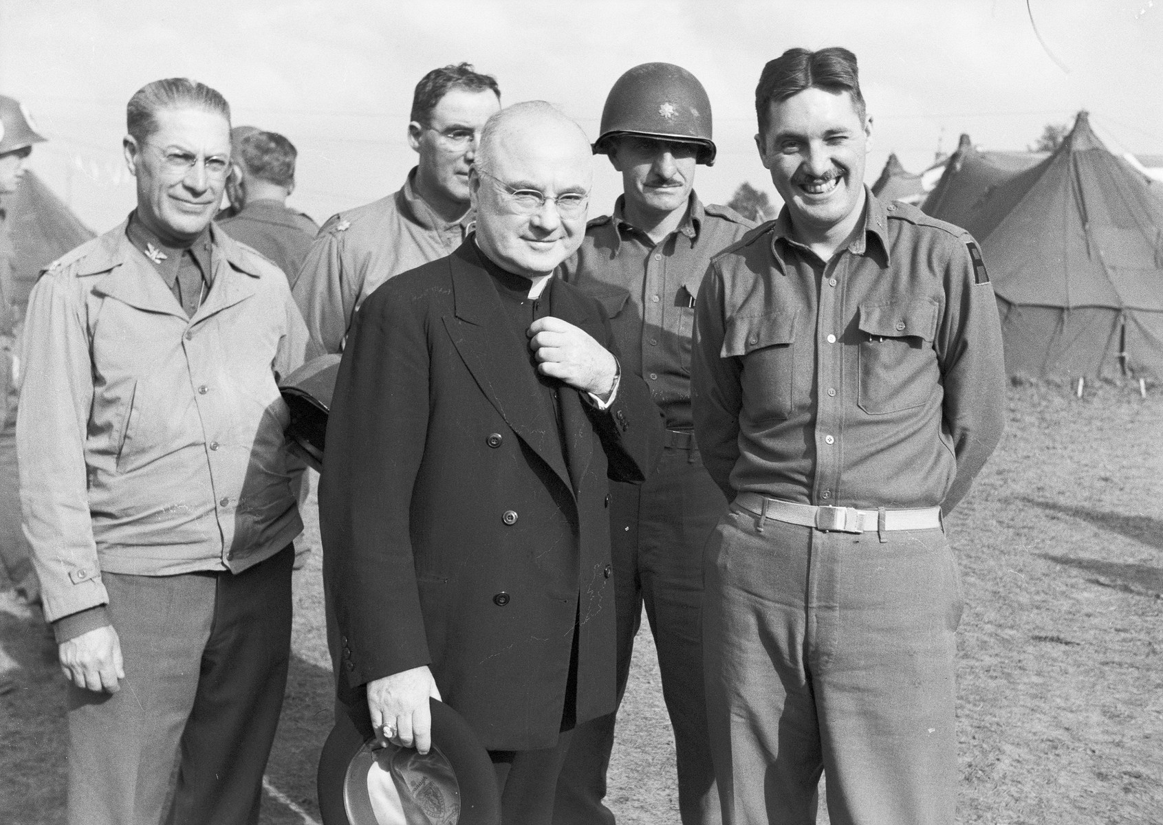 Archbishop Francis J. Spellman poses with American servicemen after the Invasion of Normandy.  

Spellman, as military vicar of the United States armed forces, traveled extensively throughout WWII.  During this time he met with military leaders and heads of state, bas well as American servicemen fighting in all theaters of the war.