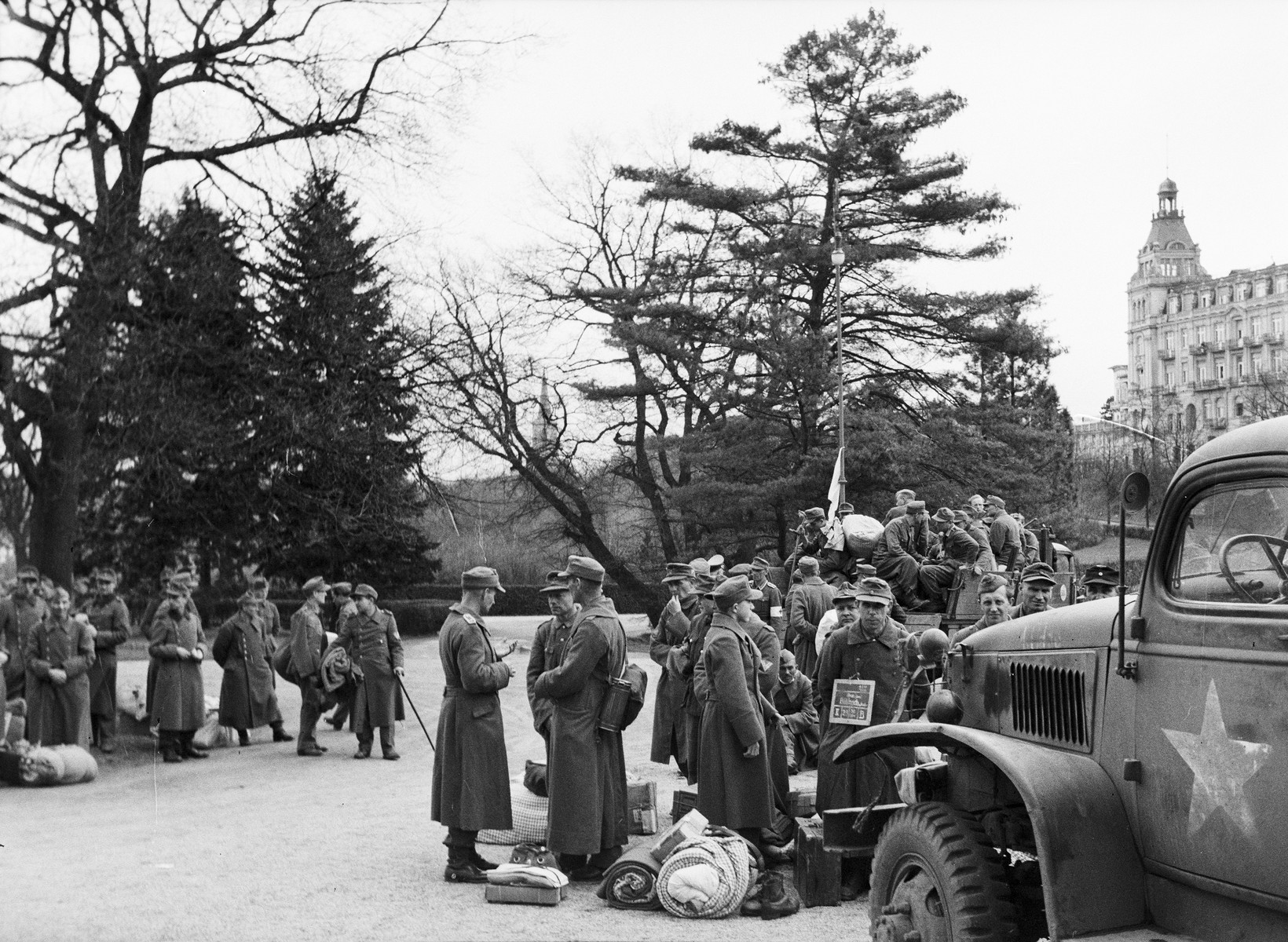 German POWs, who have been provided medical care by U.S. Army medical personnel of the 45th Evacuation Hospital, assemble before their transfer elsewhere.