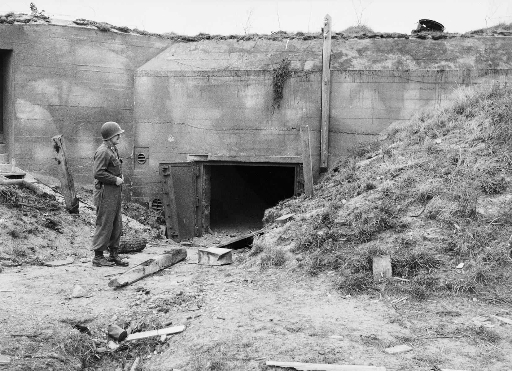 A medical officer with the U.S. Army's 45th Evacuation Hospital poses before the entrance of a fortified bunker after the Invasion of Normandy.