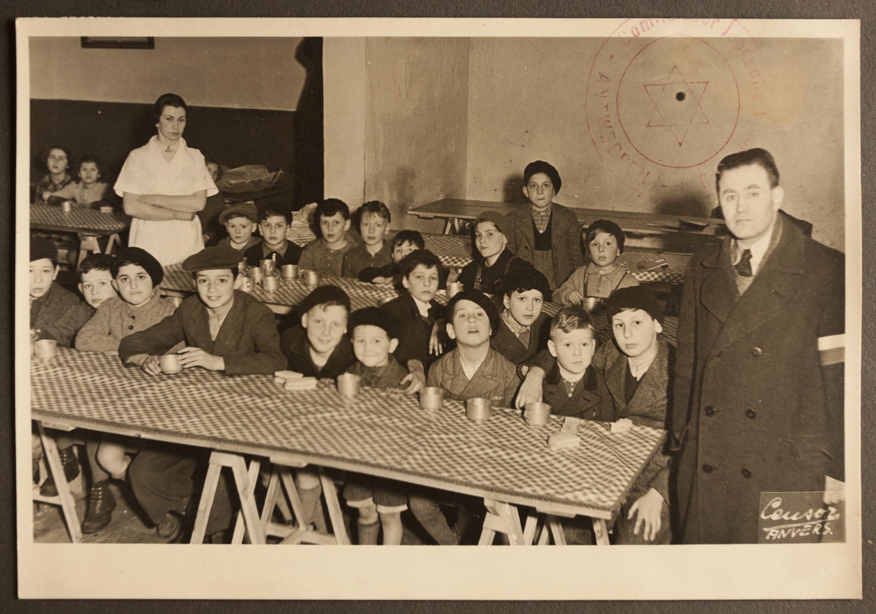 Refugee children wait to be served in the dining room of the Jewish Refugee Aid Committee of Antwerp.