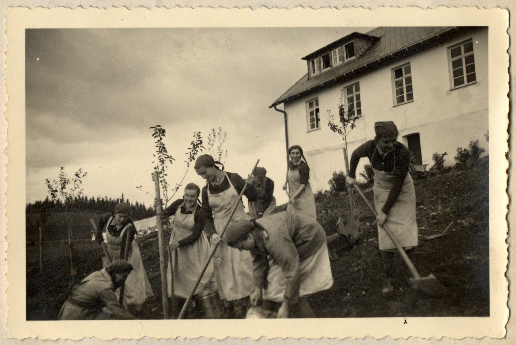 Young German women in the Reich Labor Service are photographed with agricultural tools on the estate where they are working.