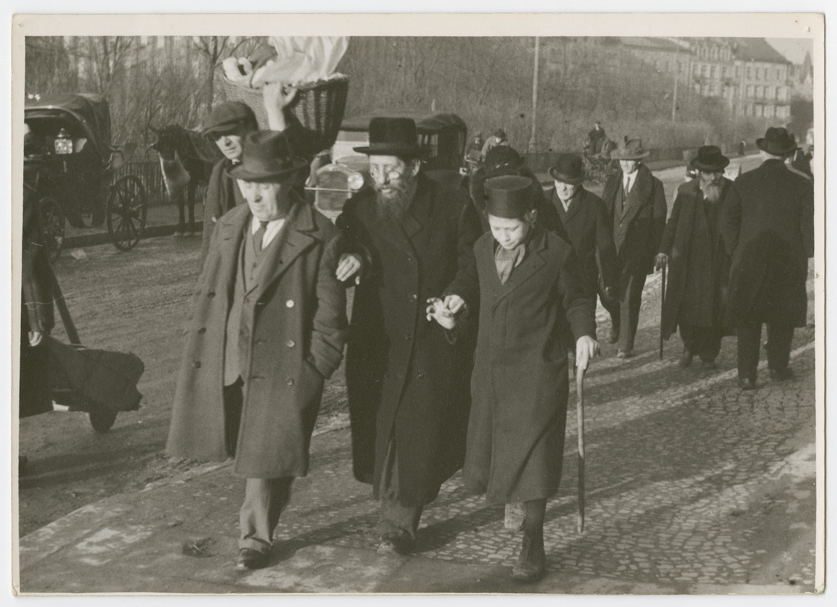 A group of religious Jews walk down a street in Karkow.

Photograph is used on page 139 of Robert Gessner's "Some of My Best Friends are Jews."