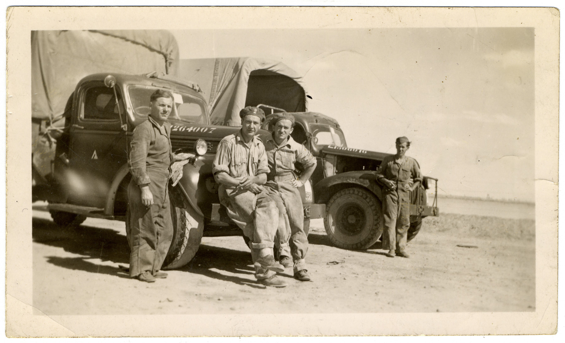 Four soldiers of the Polish Anders' Army, among them donor's cousin Mark Fruehman, are standing against army trucks in Egypt.