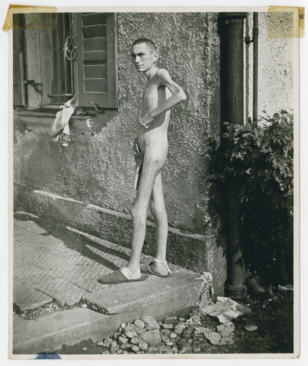 Photograph of a  naked survivor [probably in the Mueldrof labor camp.]