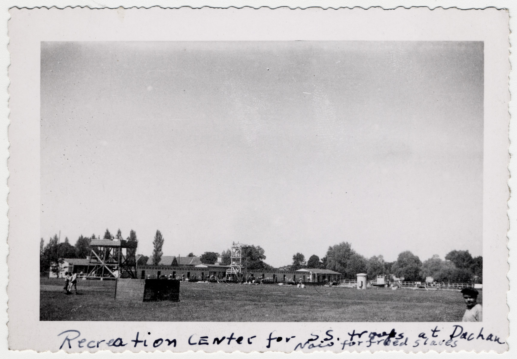 View of the SS recreation fields in Dachau following liberation.

The original caption reads "Recreation center for SS troops at Dachau now for freed slaves".