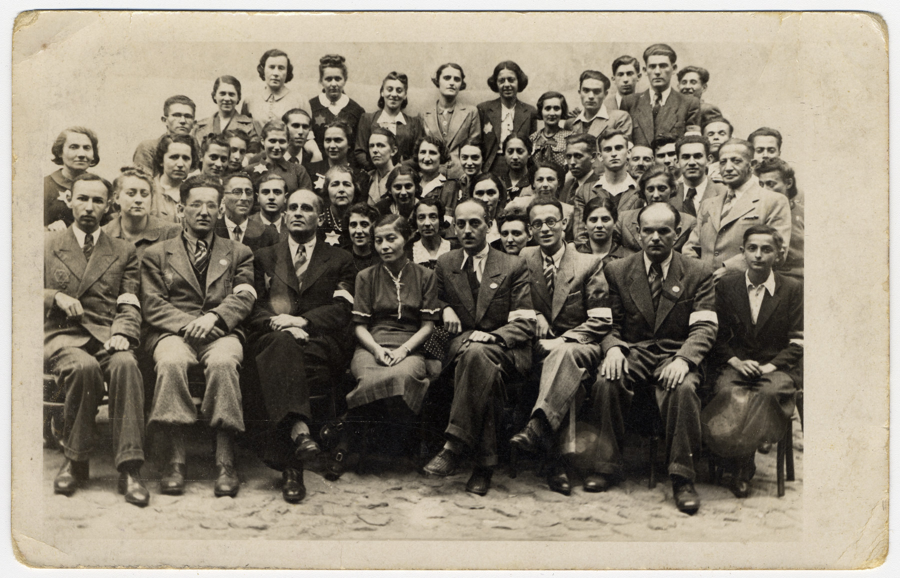Group portrait of employees of the postal service in the Lodz ghetto.  Herbert Grabe, the head of the Post Office, is sitting third from the left in the front row.