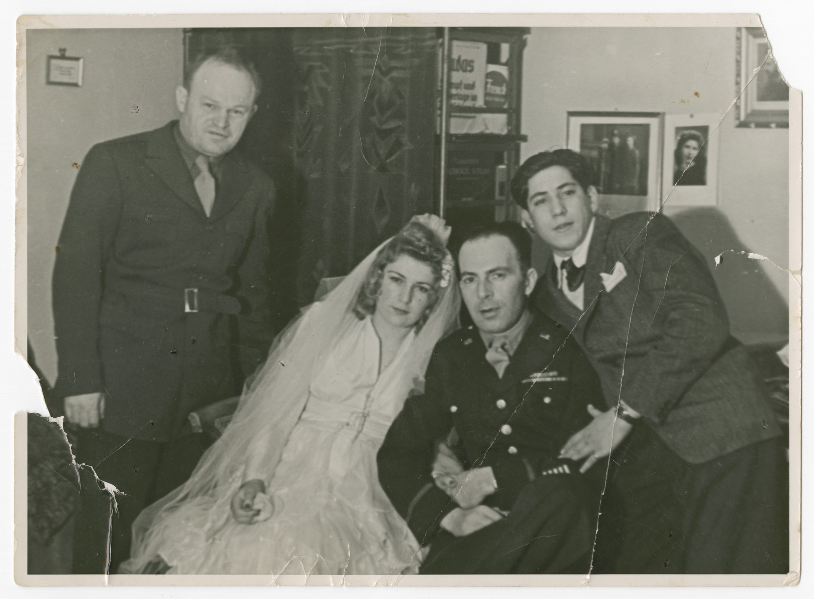 David Eizenberg (left) poses with the bride and groom at the wedding of a displaced person with an American soldier, probably in Berlin.