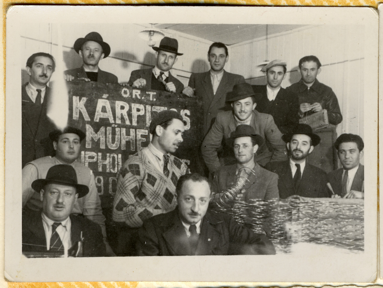 Jewish men in an ORT vocational school in the Hallein displaced persons' camp pose next to a display of mattress springs.