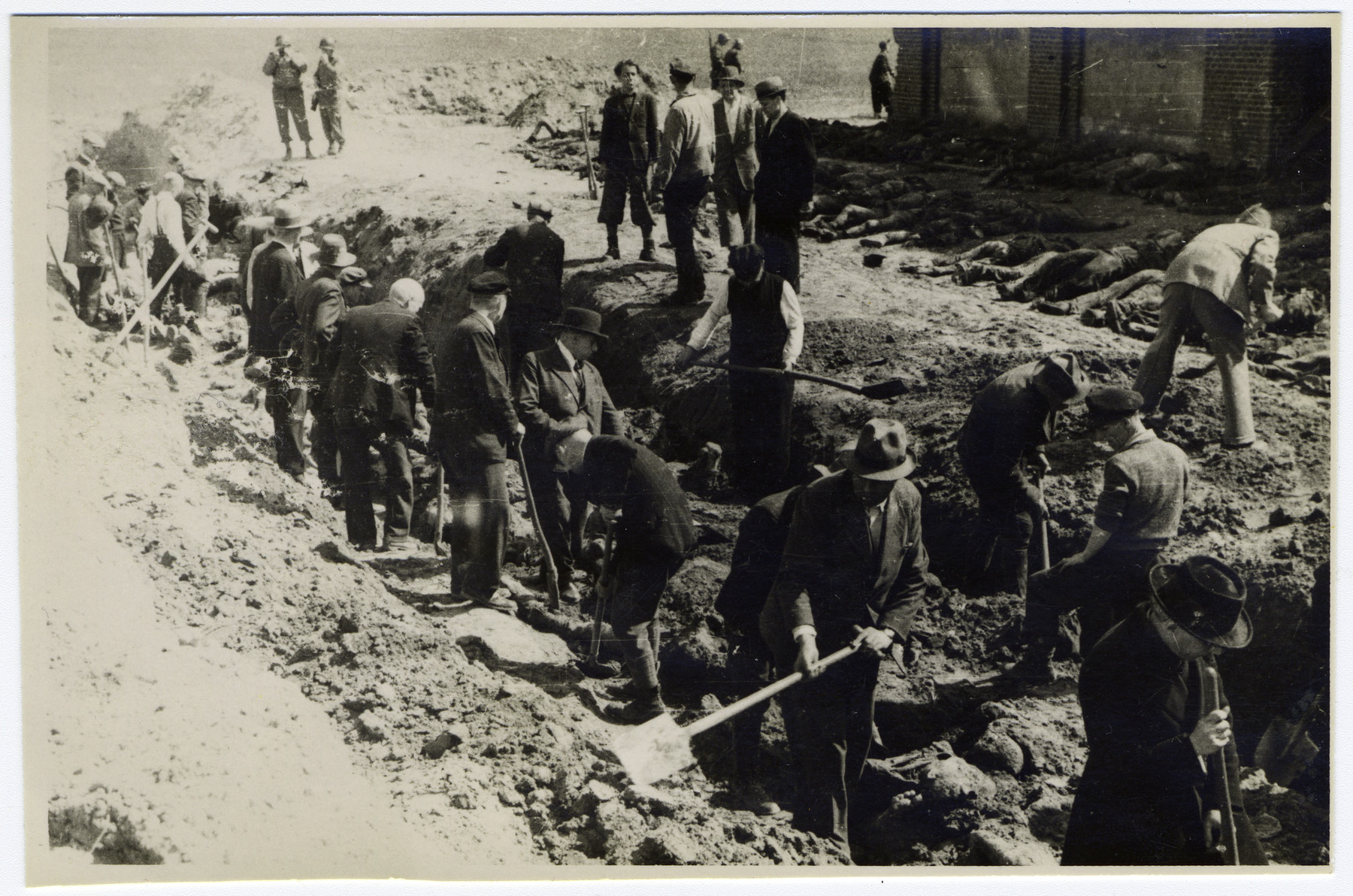 German civilians exhume a mass grave, in which prisoners who were burned alive by the SS in a barn just outside of Gardelegen were buried.