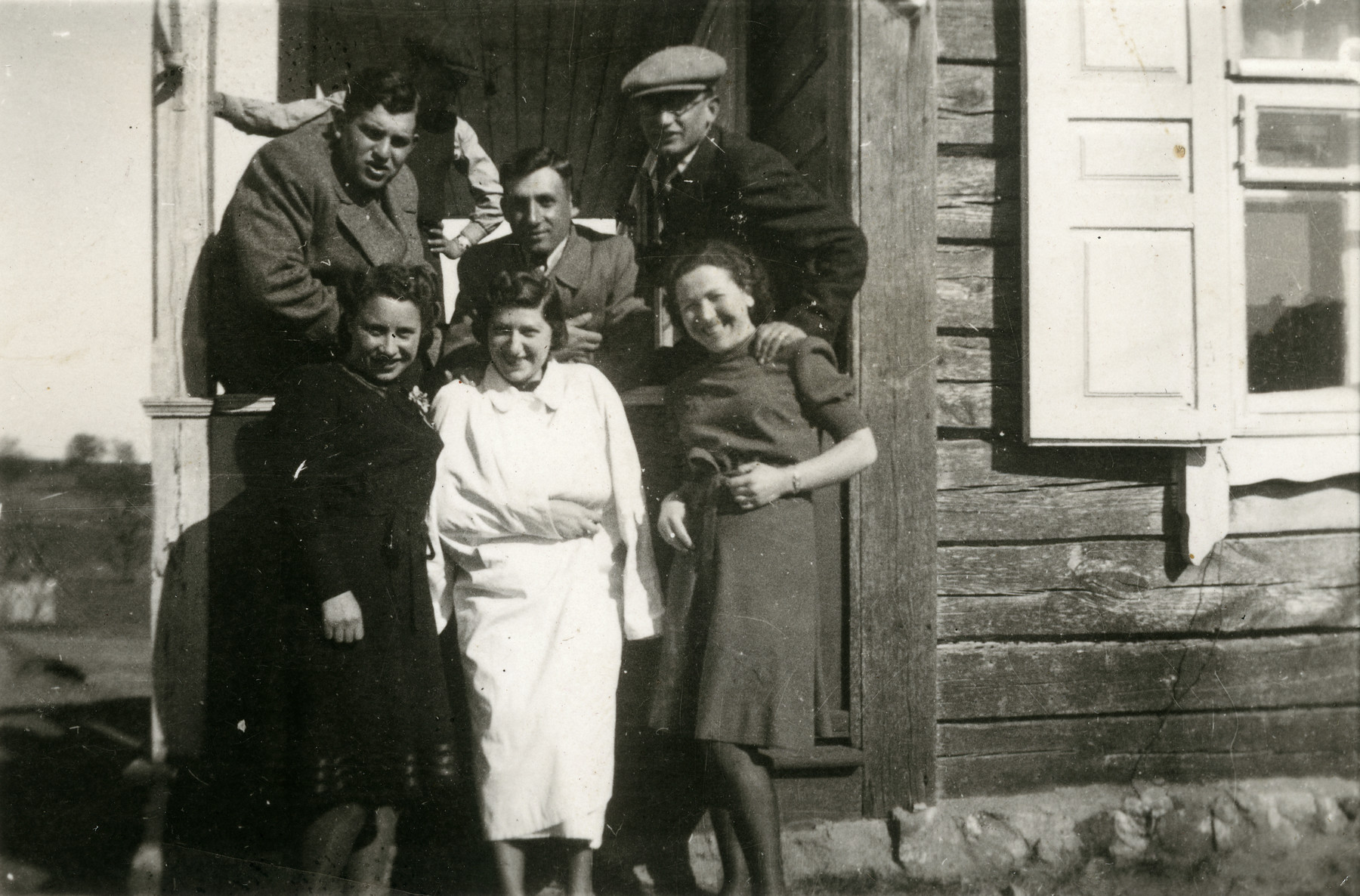 Rachel Godroff, wearing a white coat in the center, with friends in front of their house in Vievis in 1940.