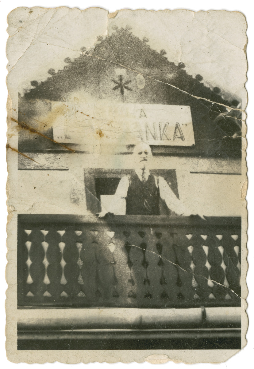 Don Mordechi Adam stands on the balcony of an unidentified building.