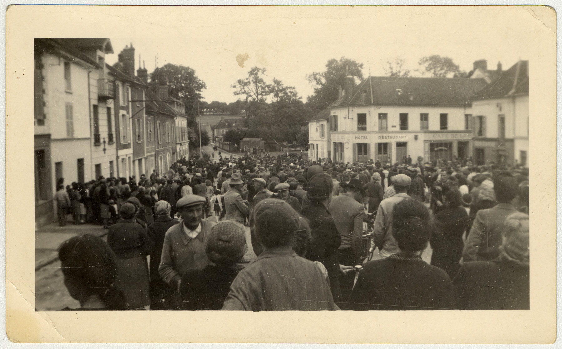 A large crowd gathers to watch French women accused of collaboration have their heads shaved.

The original caption reads: "The crowd that gathered to see the German collaborators get their hair shaved off.  Taken in France."