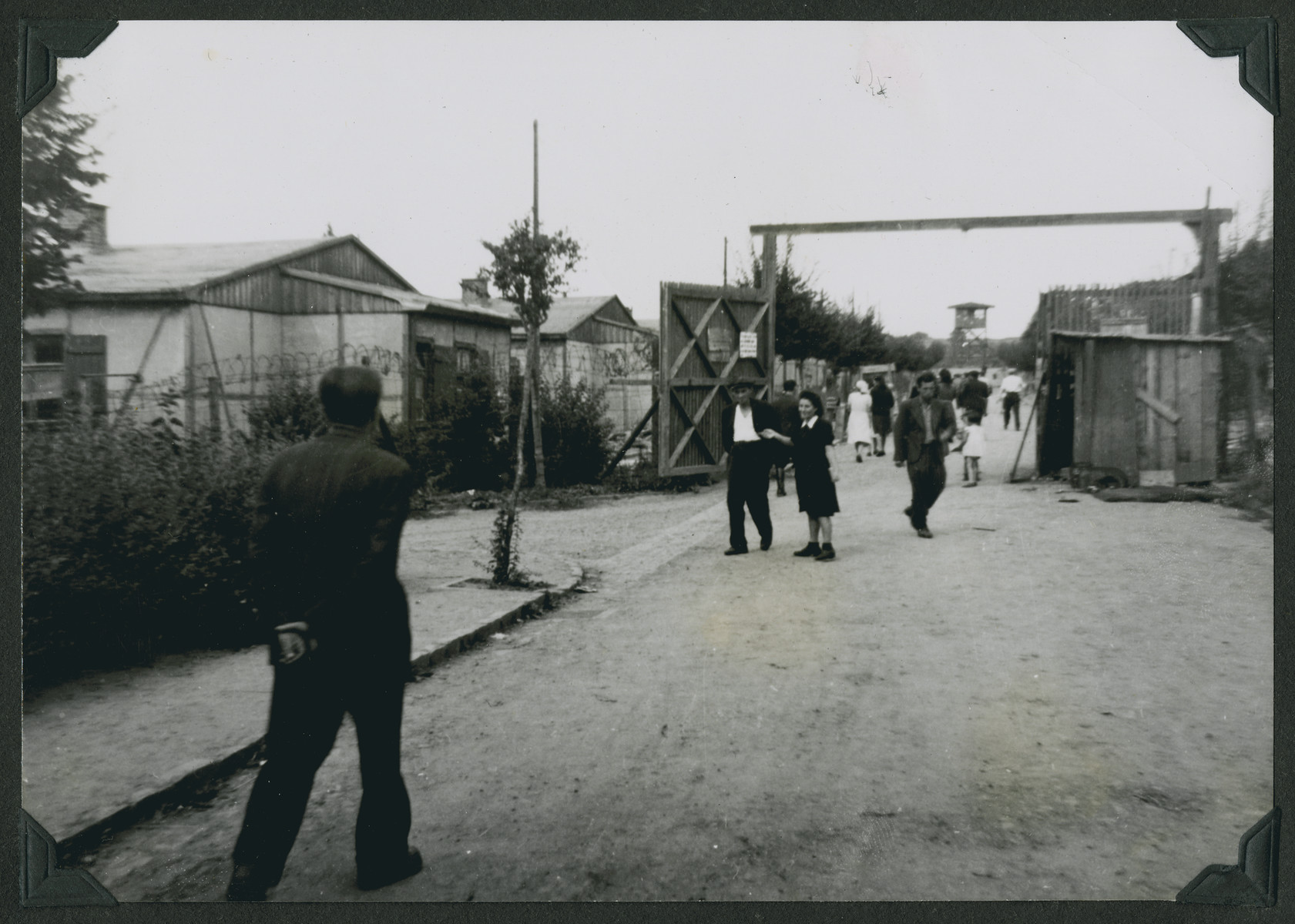 Jewish displaced persons enter the main gate of the Ziegenhain displaced persons camp.

The original caption reads: "Ziegenhain.  This is the gate for refugees.  Enter here and you shall suffer. -- the inner gate of the camp."