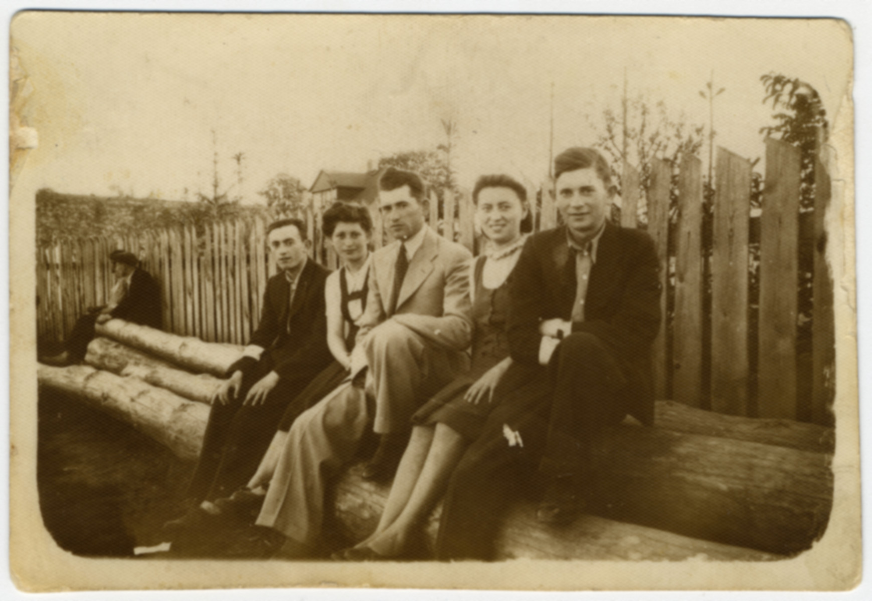 The Luksenburg family poses on some large logs shortly before the start of World War II.

Pictured from left to right are a friend (name unknown), Rivka, Mosche, (unidentified) and Kopel Luksenburg.