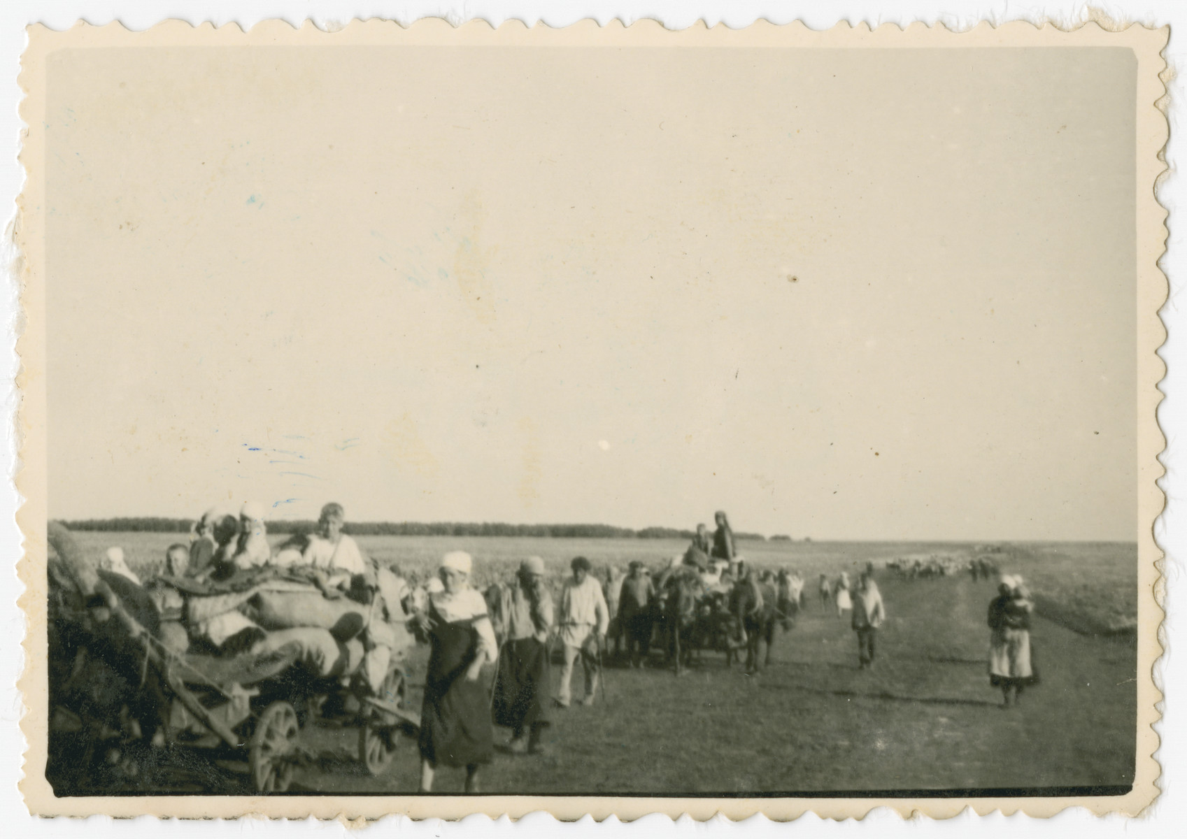Photograph of civilians and wagons laden with  personal belongings taken during a possible resettlement action.