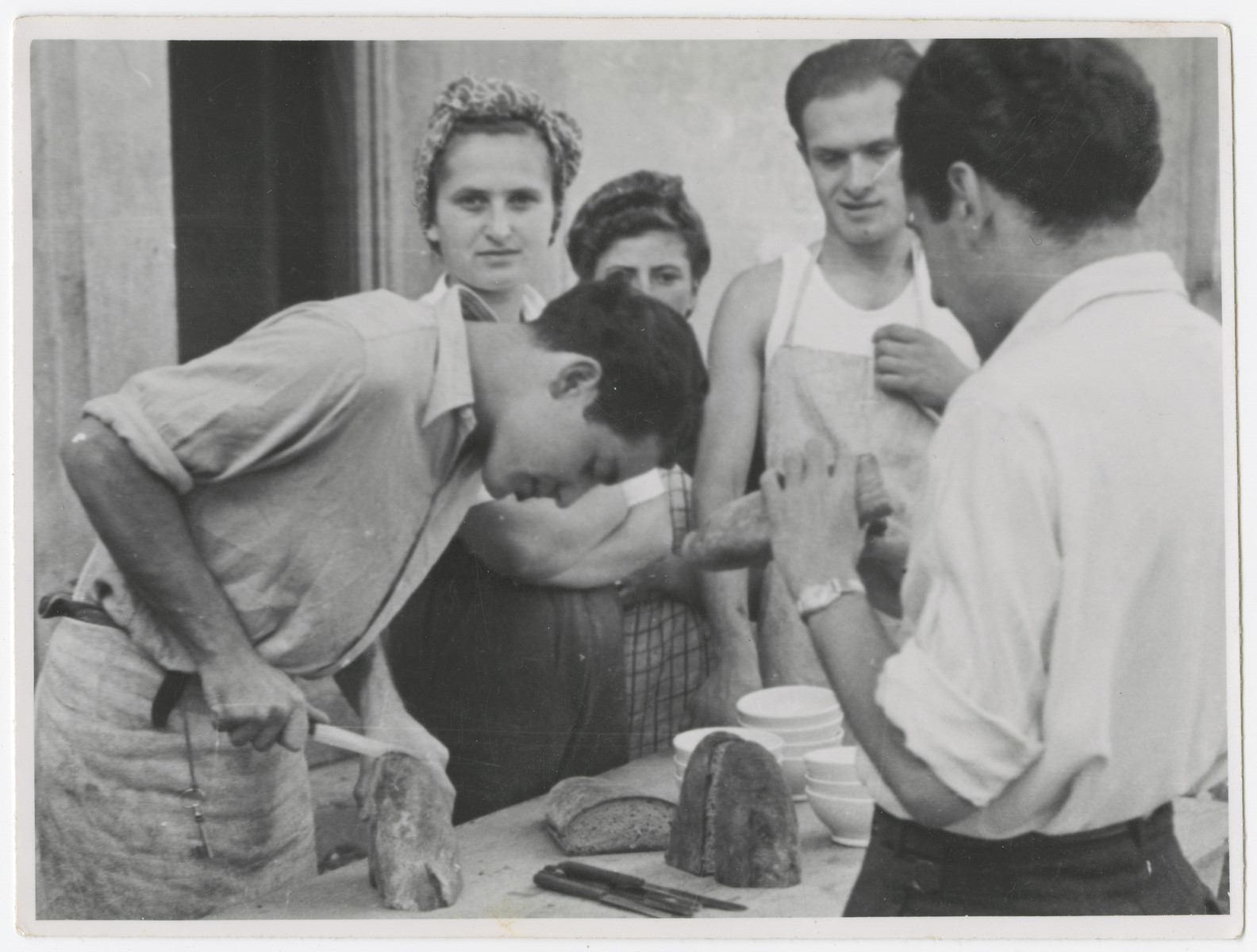 Zionist youth, some who came to Switzerland on the Kasztner transport, prepare a meal in a kibbutz hachshara near Bern.

Eva Weinberger is pictured second from the left facing the camera.  Berta Rubinsztajn is next to her partially obscured.