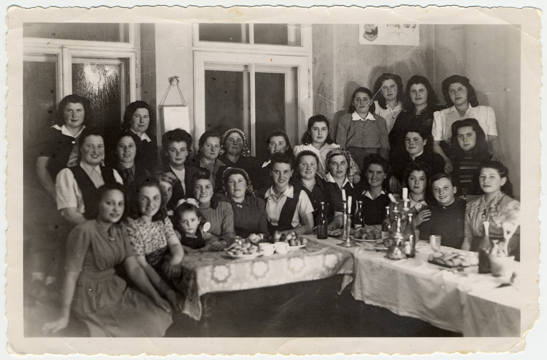 Religious Jewish women gather around a table for a celebration in the Bad Gastein displaced persons' camp.

Among those pictured are Esther and Itka Ass (seated left).