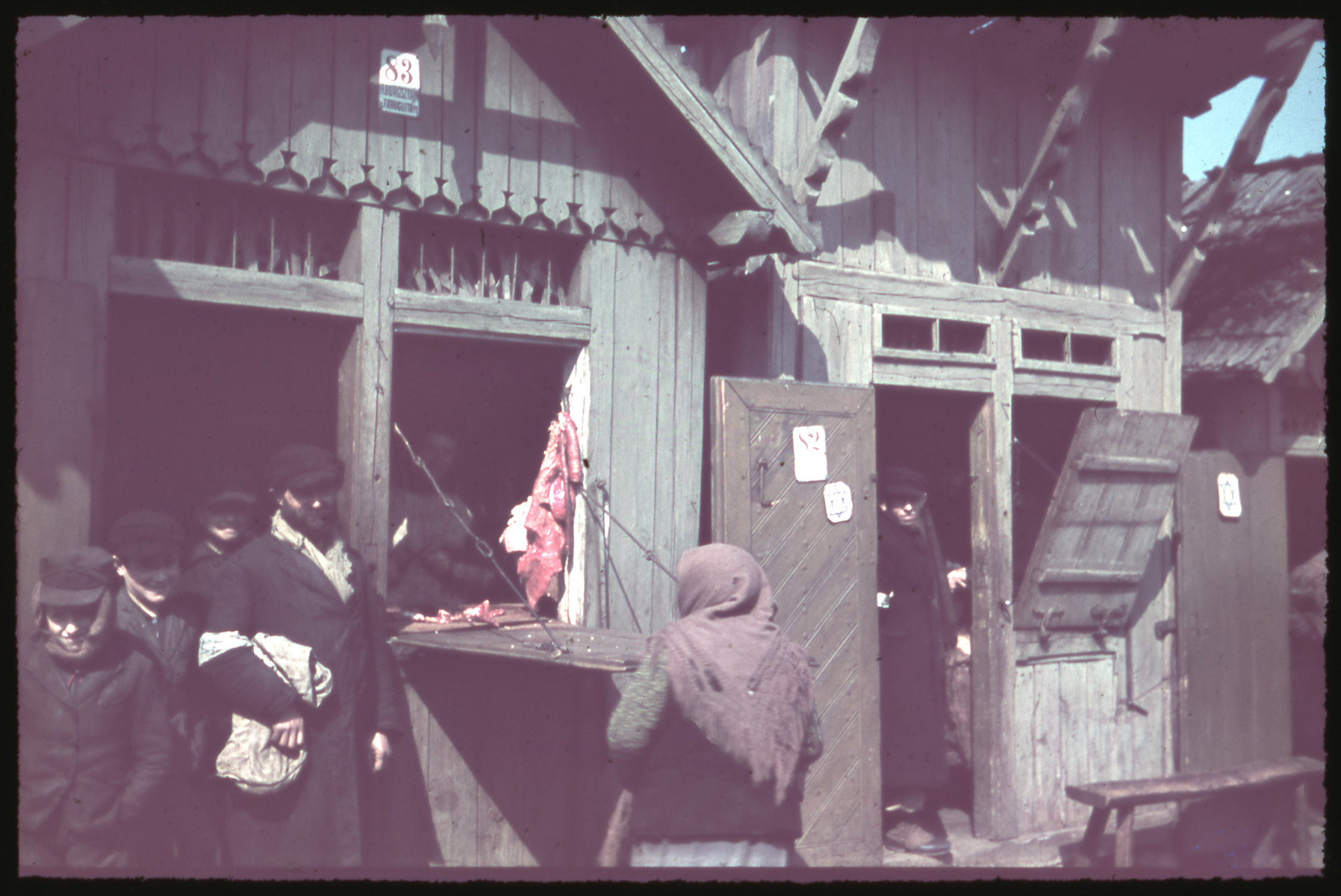 Jews shop in a store marked with a Jewish star on its door [possibly in Kozienice].