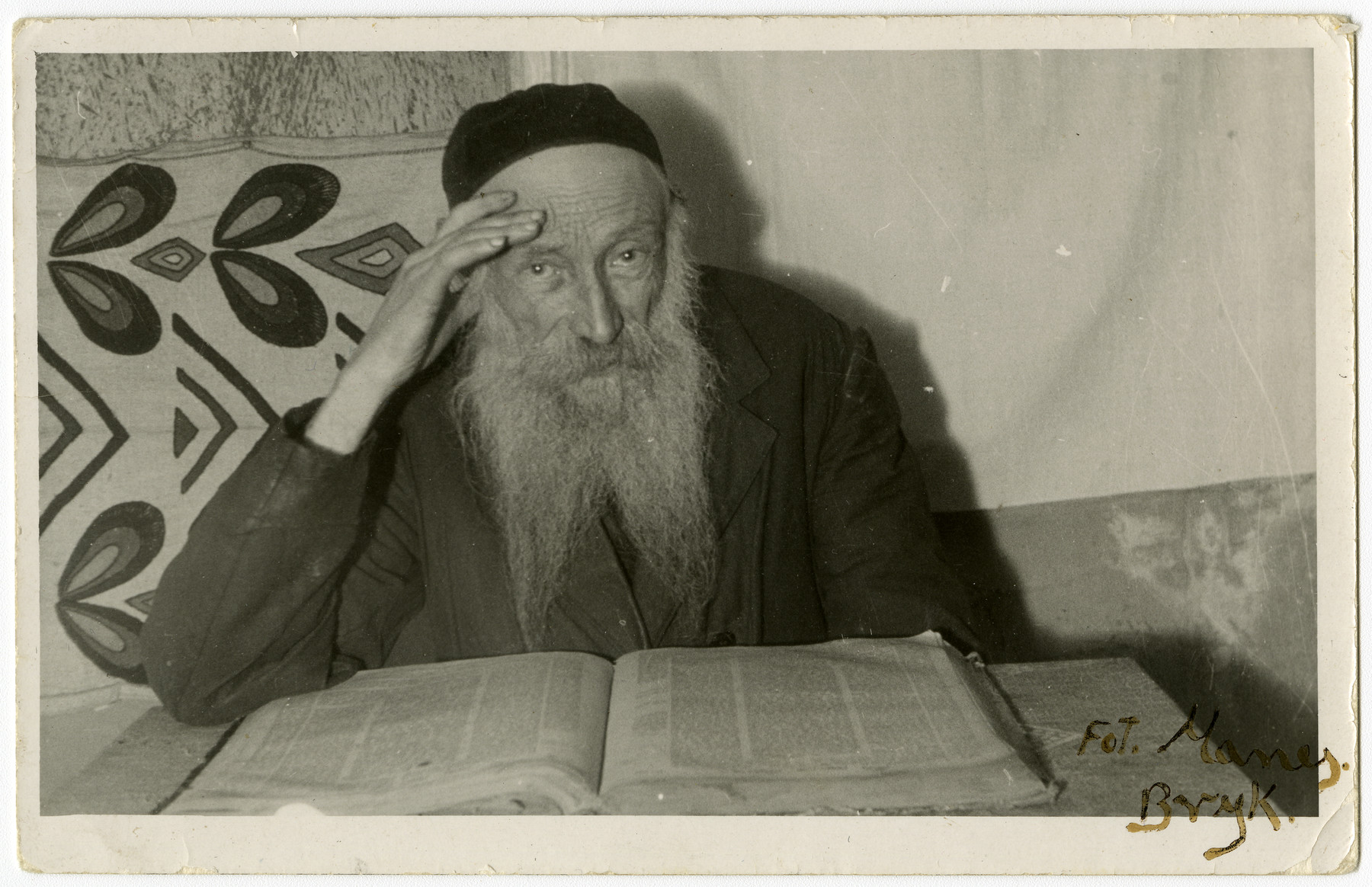 Studio portrait of Reuven Schwartz studying a Jewish text.