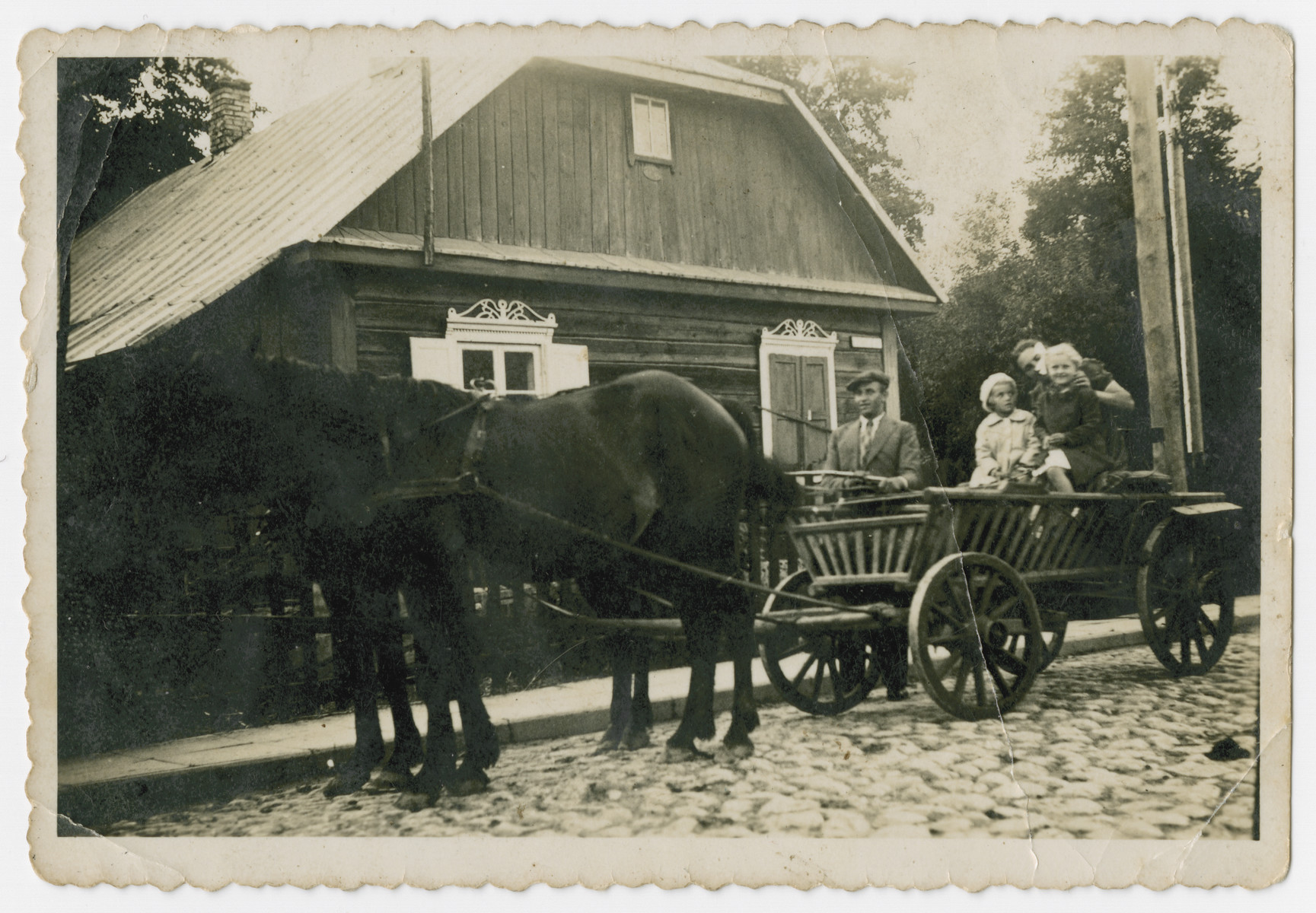 A group or people ride in a horse drawn cart down a street in prewar Butrimonys.

Part of a collection of photographs depicting Jews from Butrimonys where some 750 Jews were rounded up and murdered by the Einsatzgruppen and Lithuanian collaborators after the invasion of the USSR.Part of a collection of photographs depicting Jews from Butrimonys. Some 750 Jews were rounded up and murdered by the Einsatzgruppen and Lithuanian collaborators after the invasion of the USSR.