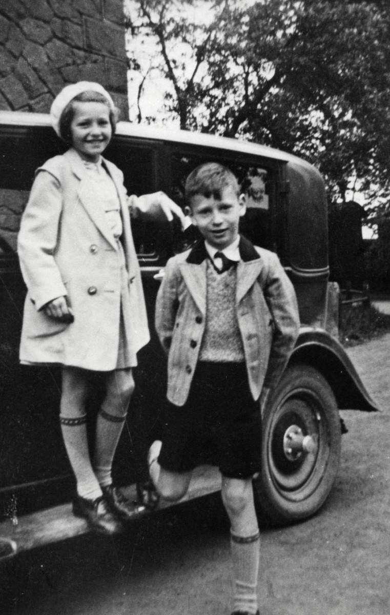 Erika and Werner Loebl stand on the running boad of their family's Opel.