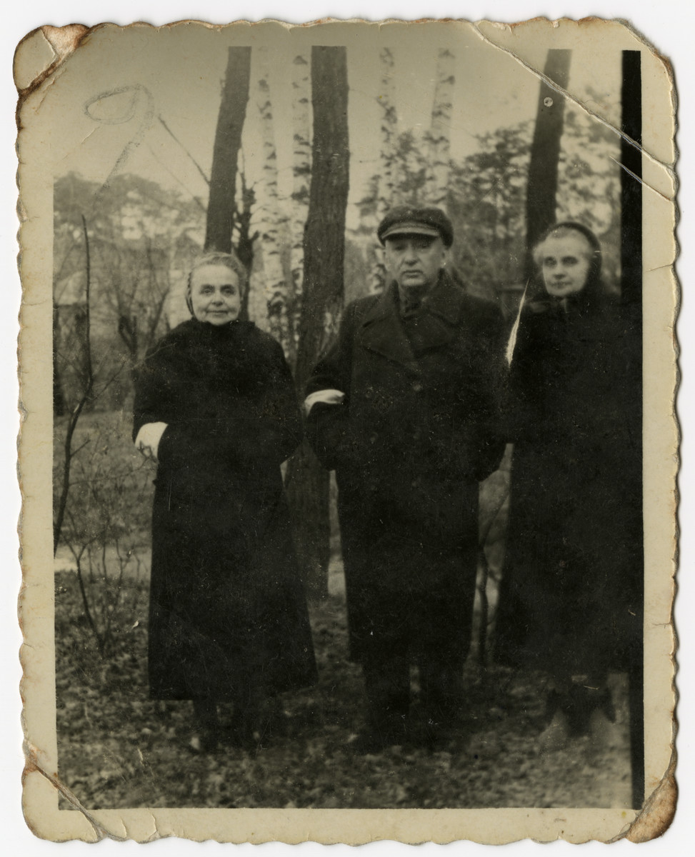 Three elderly Jews pose in the woods behind the Pensjonat Zacheta, outside the Otwock ghetto.

From left to right are Regina and Benjamin Szymin and a Regina's sister, Malka Flint.   The pension was owned by the sisters, Regina and Malka.

Benjamin and Regina Szymm enclosed this ghetto photograph in a letter to their daughter Eileen Szymin Shneiderman in New York requesting help to leave Poland for the States.