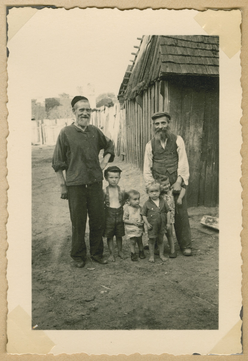 Two religious Jewish men pose with young children in Deblin-Irena.