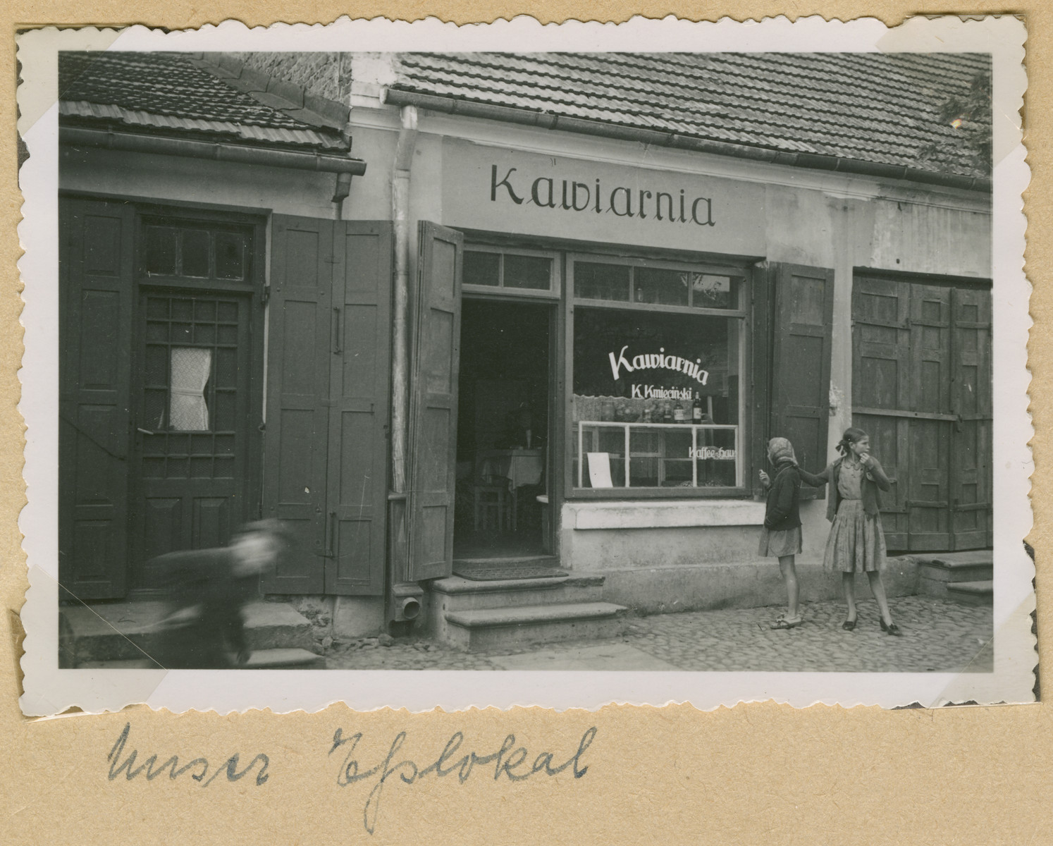 Two girls stand outside a cafe in an unidentified Polish town [probably in the Lublin district.]

The original caption reads: "Our eating place."