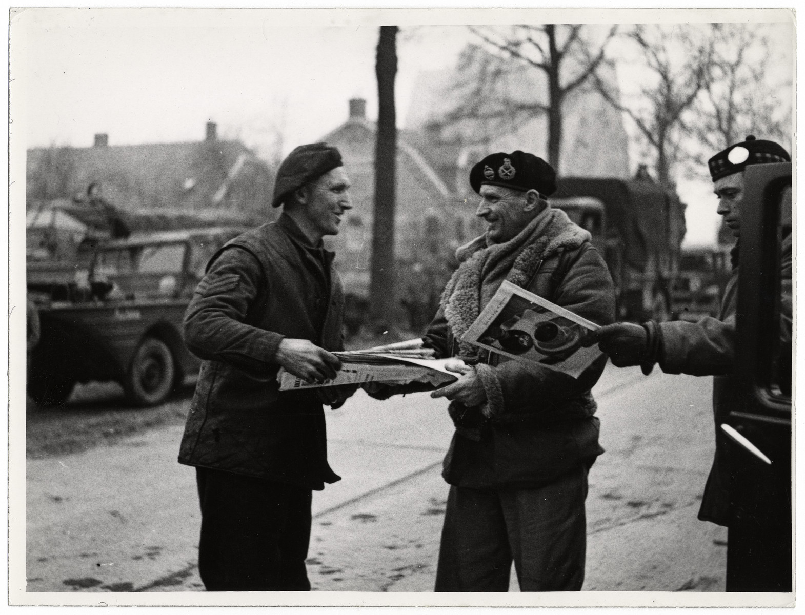 Field Marshal Bernard Montgomery visits British troops in Germany.

Original Caption: "Field Marshal Sir Bernard L. Montgomery has visited the British troops in the Cleve area, Germany. He arrived in a Dukw amphibious lorry. He took with him magazines, newspapers and cigarettes for the men."

This picture shows: On his return journey, the Field Marshal stops and gives some books to Sergeant Snelling (s outhall) R.A.S.C."