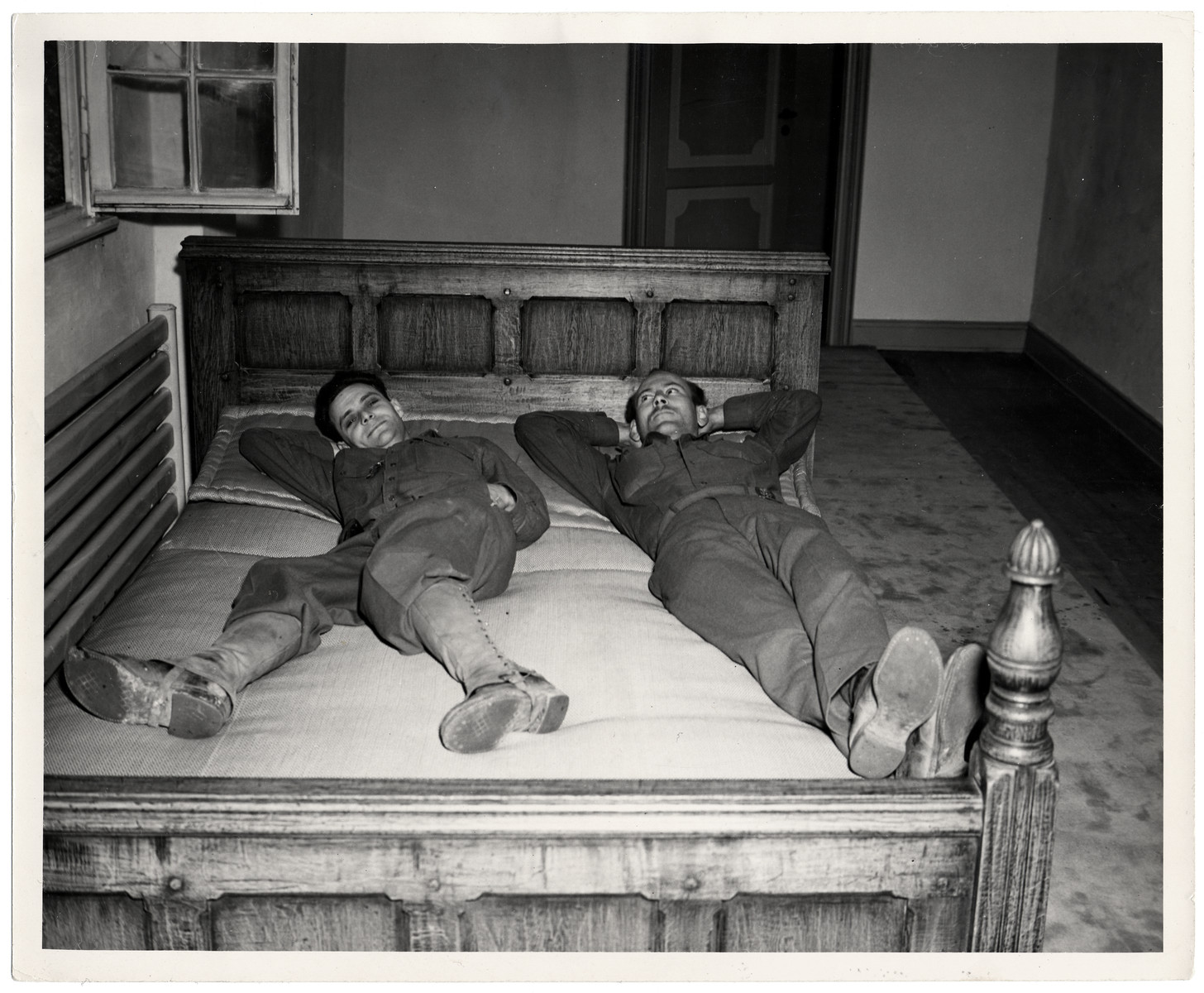 Sgt. Everett Steiger from Salem, Oregon and T/4 Joseph W. Eaton relax on the bed that had belonged to Joseph Goebbels at Schloss Rheydt. 

It was moved into the hallway by the GI's who are now billeted in the castle and need his room.