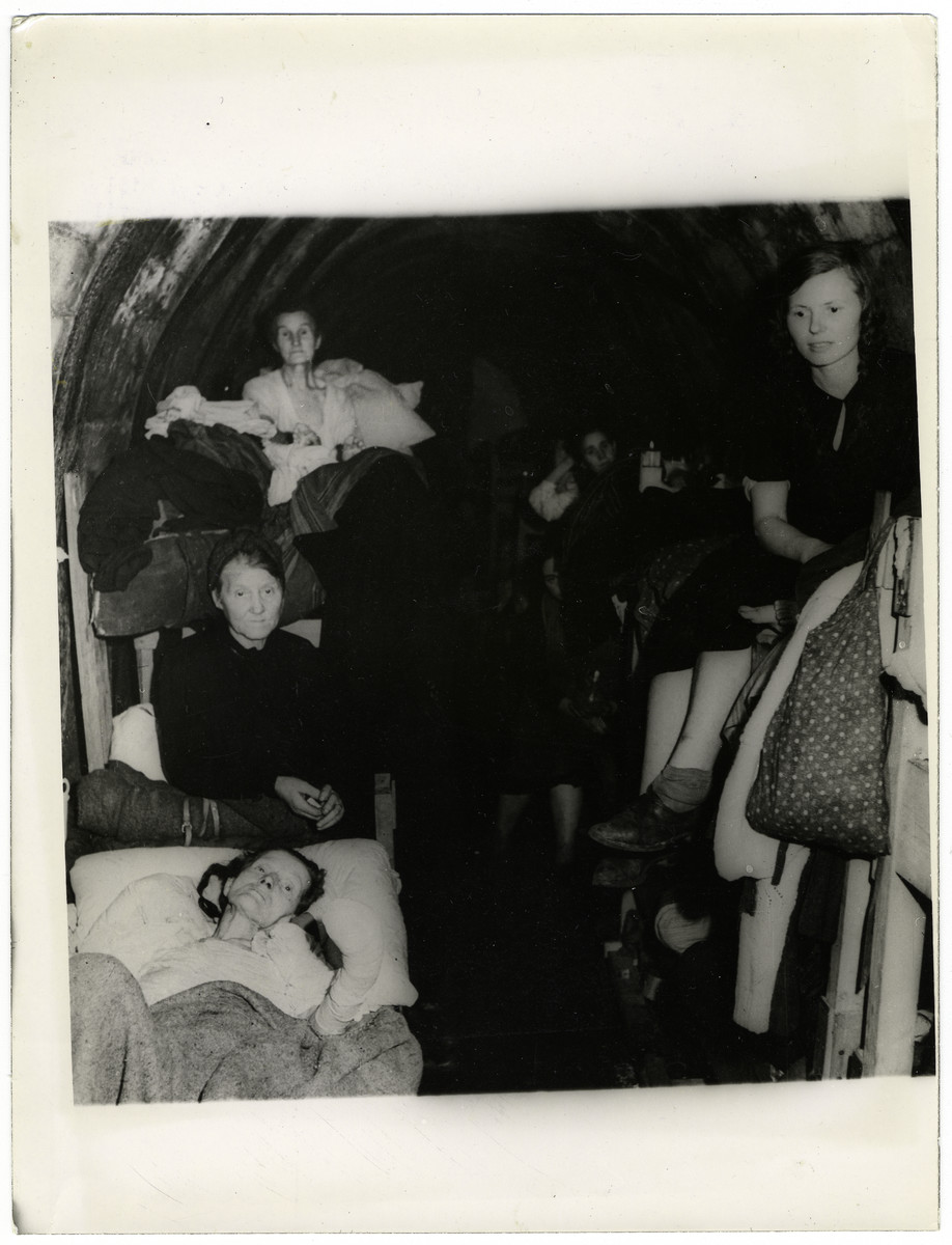 German women living in primitive dwellings in a mine surrender to American troops.

The original caption reads, "About 7,000 German civilians recently surrendered to Ninth U.S. Army troops after going with little food or water for four days in a shelter in the shafts of a mine slag pile in the Ninth Army sector east of the Rhine River, Germany. Previously, when they attempted to hoist the white flag, Nazi troops fired into their  midst with machine guns."

This photo shows: "German women of the group are pictured inside the primitive dwellings."
