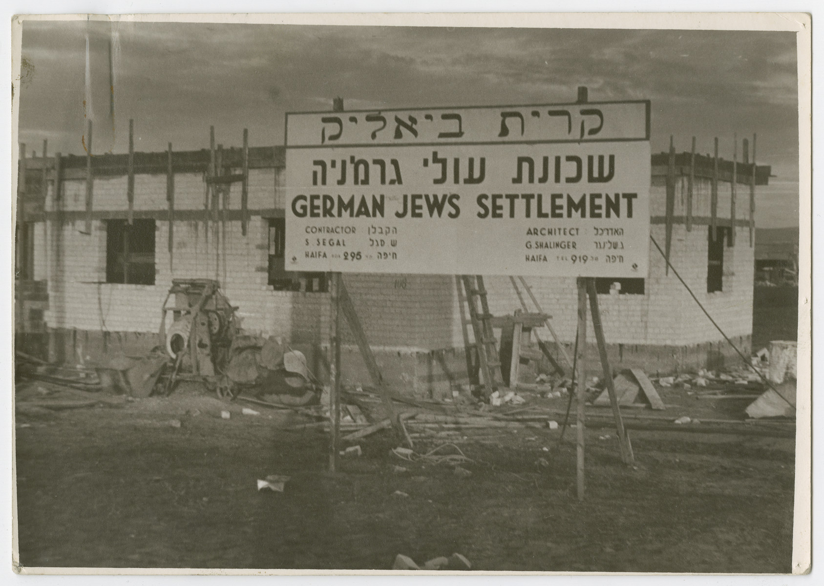 View of the sign announcing the construction of Kiryat Bialik, a new settlement for German Jews.

Photograph is used on page 210 of Robert Gessner's "Some of My Best Friends are Jews." The typed caption attached the photograph reads, "One of the German Jewish colonies constructed in the outskirts of Haifa."