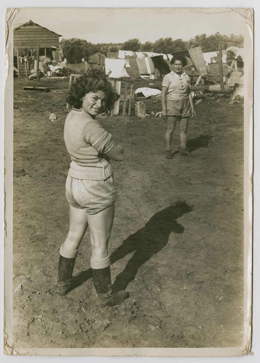 Two woman stand in a muddy field in front of a laundry line in a new settlement, possible Hadera.

Photograph is used on page 197 of Robert Gessner's "Some of My Best Friends are Jews." The pencil inscription on the back of the photograph reads, 'Farm Palestine."
