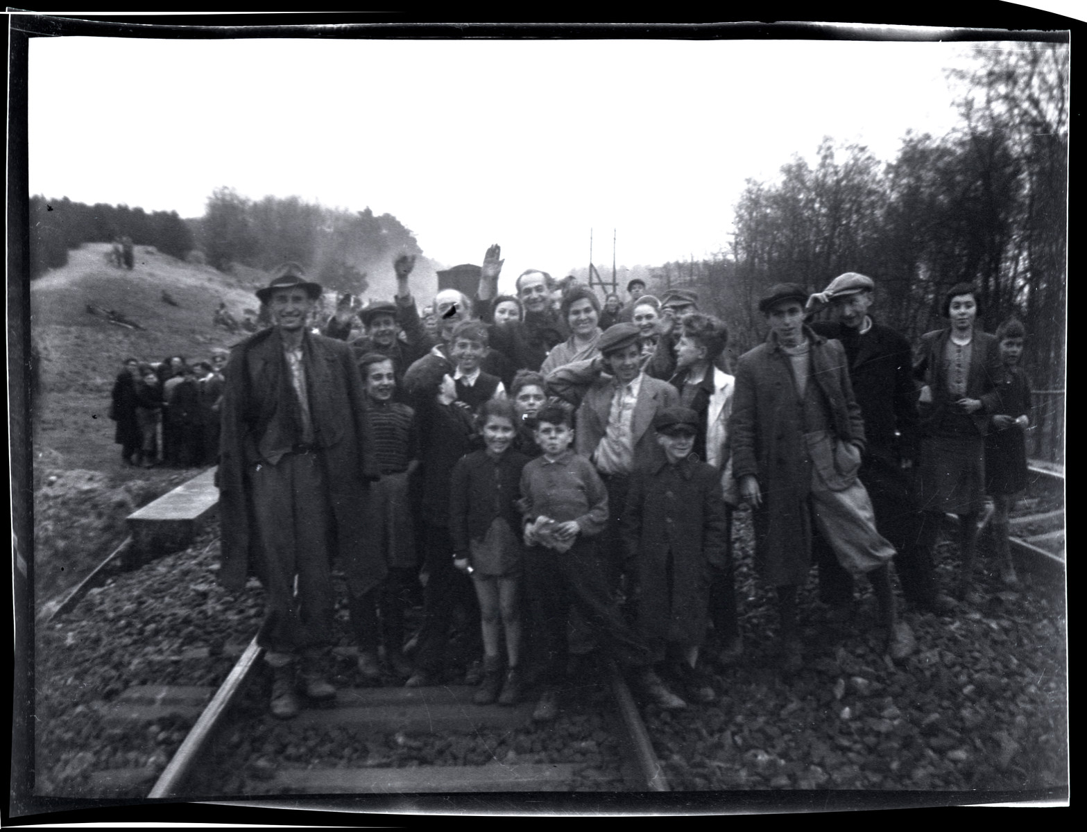 Survivors from Bergen-Belsen pose by the train tracks shortly after their liberation.
