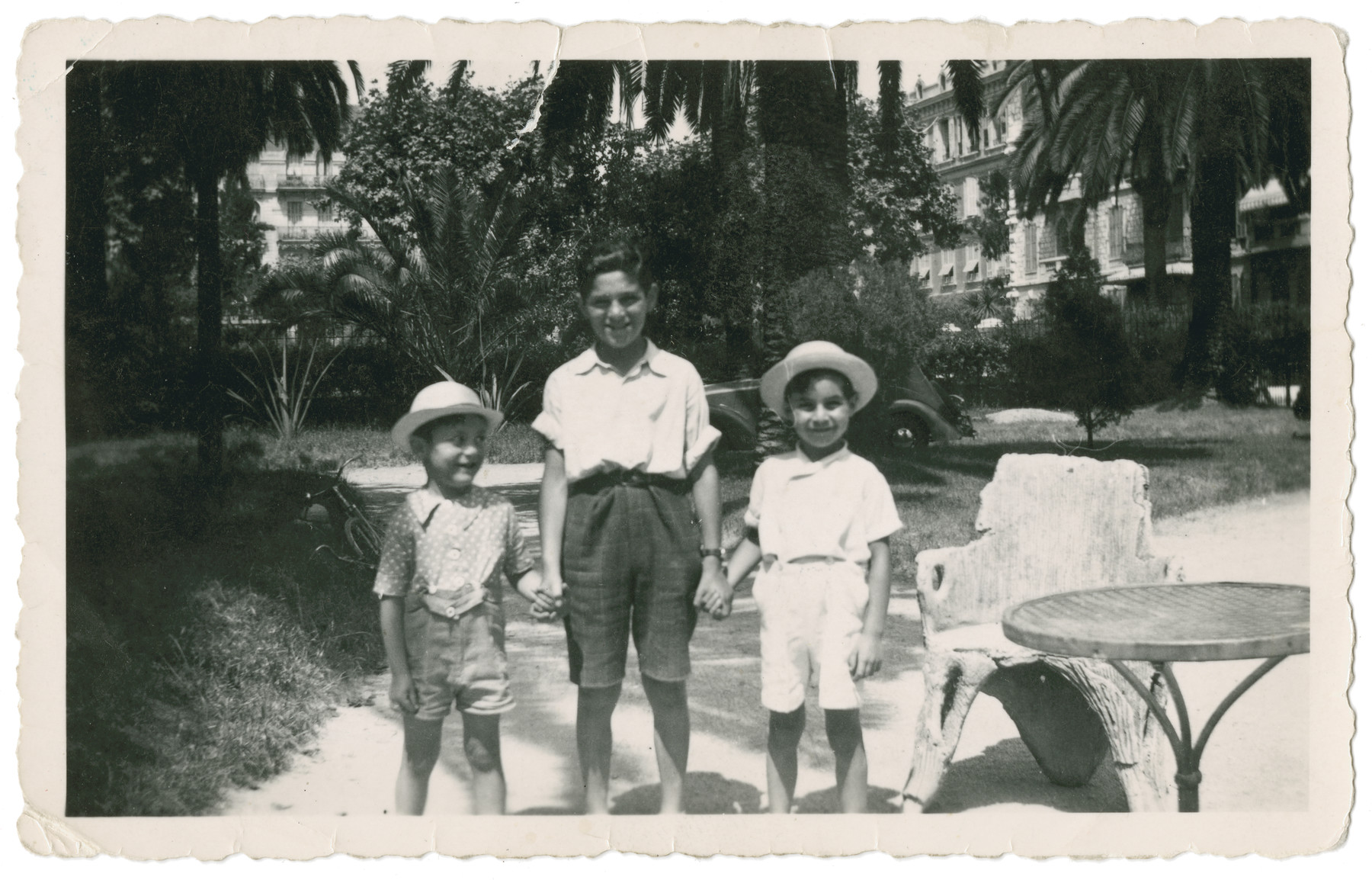 Three boys pose underneath the palm trees of the Hotel Continental in Nice.

From left to right are Fred and Leo Gross and their friend Mikey Abet.